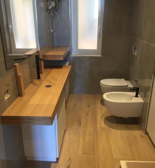 Bagno in stile contempraneo con effetto marmo in parerta e legno a pavimento presso abitazione privata di Corso Firenze, Genova